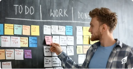 Person managing tasks on a whiteboard